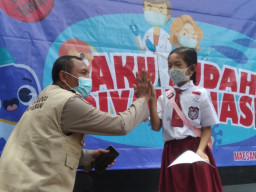 Dipangku dan Tos! Trauma Healing Vaksinasi dari Polisi ke Siswa SD di Bondowoso