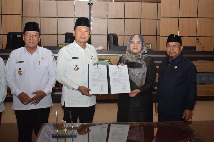Pimpinan DPRD dan bupati menunjukkan berita acara penandatanganan persetujuan Raperda. SP/MUHAJIRIN KASRUN