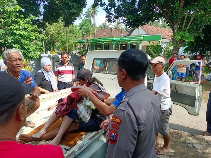 Warga dibantu petugas saat mengevakuasi nenek yang tercebur di dalam sumur. SP/Hadi Lestariono