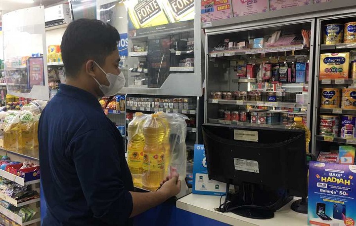Seorang customer membeli minyak goreng minimarket
