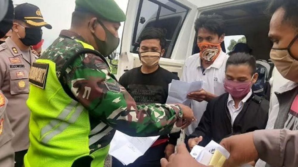 Pekerja migran yang kedapatan melintas di berhentikam petugas di cek poin perbatasan Gresik Lamongan di Kecamatan Duduksampeyan, kemarin.