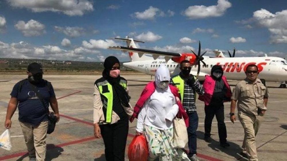 Tersangka kasus dugaan tindak pidana korupsi penyaluran fasilitas kredit pada bank NTT Cabang Surabaya, Willyan Kodrata dan Loe Mei Lien saat turun dari pesawat pada Senin (6/7/2020) pagi.