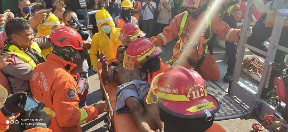 Petugas mengevakuasi Martinus Maneno yang terluka karena tersengat listrik.