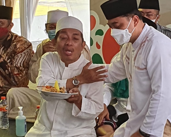 H. Syukur, perwakilan pedagang Pasar Turi menerima tumpeng dari Wali Kota Eri Cahyadi.