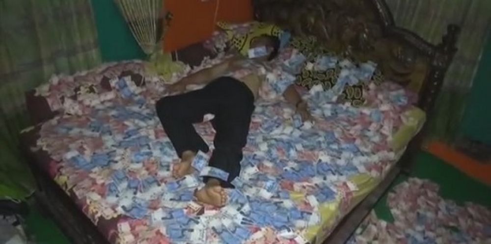 Aksi Nono tidur di atas tumpukan uang.