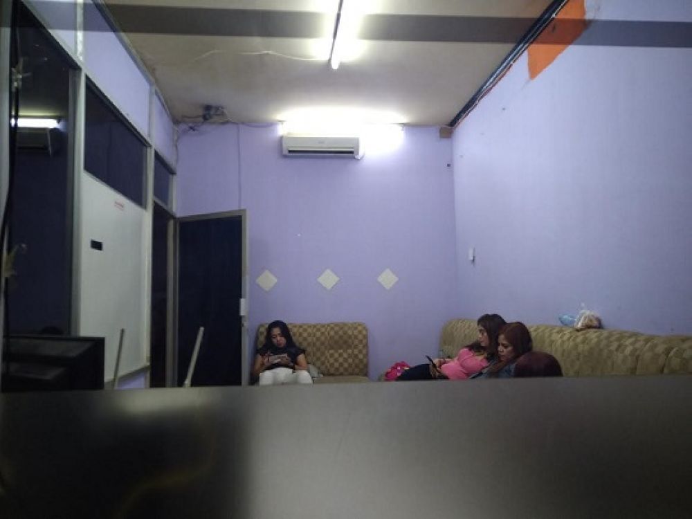 Para therapis menunggu panggilan dari customer mereka via MiChat, di salah satu panti pijat plus-plus kawasan Surabaya Barat.