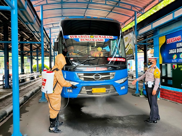 Kanit Turjawali Lantas Polres Lamongan saat ikut mengawal  menyemprotkan ke badan kendaran bus di Terminal. SP/MUHAJIRIN