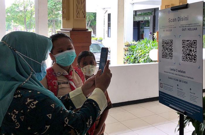 Salah satu pengunjung melakukan scan QR Code Aplikasi PeduliLindungi.