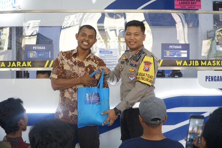 Kasat lantas Polres Pasuruan saat memberikan hadiah kepada salah satu warga pemohon SIM