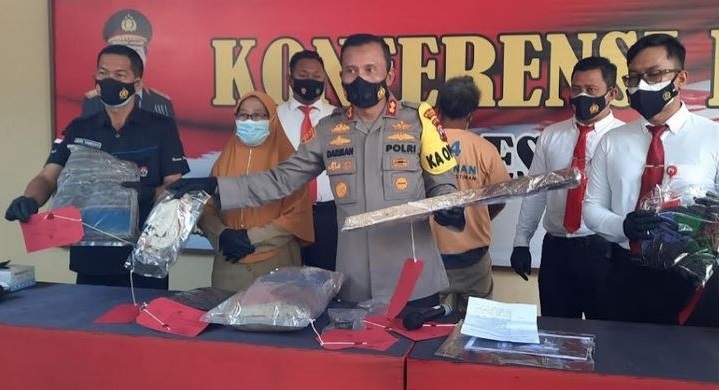 Kapolres Tuban, AKBP Darman menunjukkan barang bukti kayu balok yang digunakan tersangka pembunuhan tetangganya sendiri gara-gara mendapat bisikan gaib.