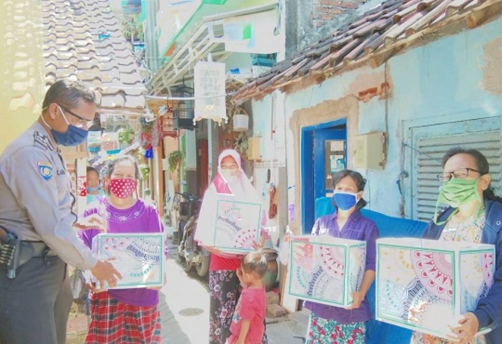 Aiptu Lagiman membagikan Sembako untuk 4 orang warga Jalan Tanah Merah, Jum’at (15/4). SP/tyan