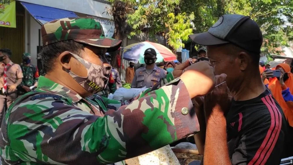 Anggota TNI-Polri Bagikan Masker Gratis di Pasar Tradisional Jombang
