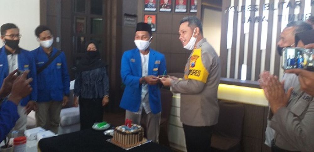 Kapolres Blitar Kota menerima potongan kue tart ucapan selamat hari Bhayangkara dari mahasiswa PMII yang saat itu berkunjung ke Polres Blitar Kota, Selasa (30/6). SP/Les