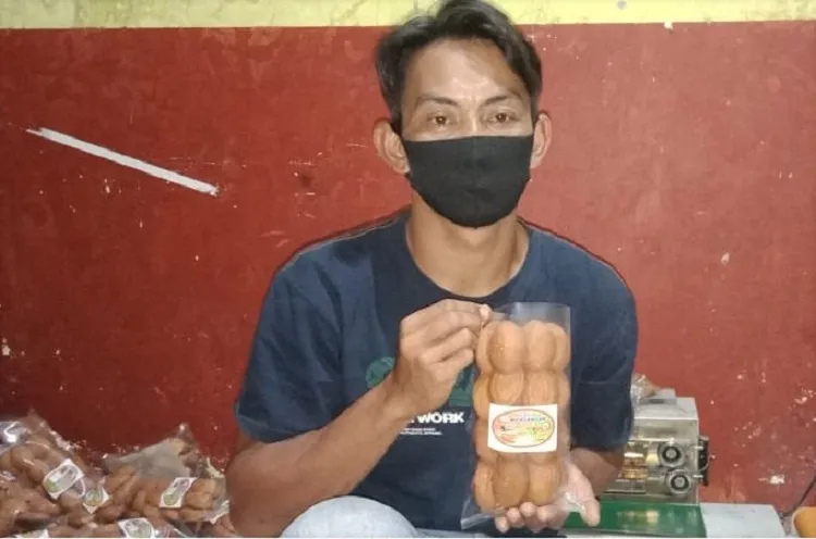 Cosi Hasmoro dengan roti bolu khas Magetan produksinya. SP/ MGT