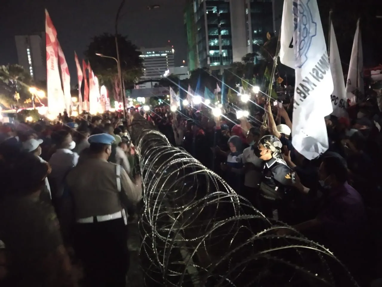 Demo hingga Malam, Buruh Gunakan HP untuk Ganti Lampu