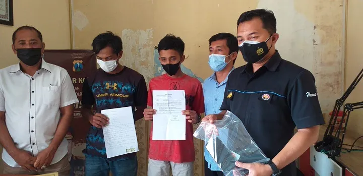 Dua pelaku pembuat konten WA, dalam releasnya menunjukkan surat pernyataan dan 2 buah Hp yang timbulkan masalah. SP/Hadi Lestariono