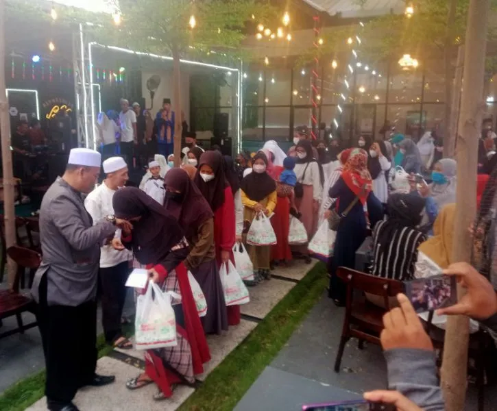 Abah Sueb saat membagikan santunan kepada ratusan anak yatim piatu di BS Cafe miliknya.