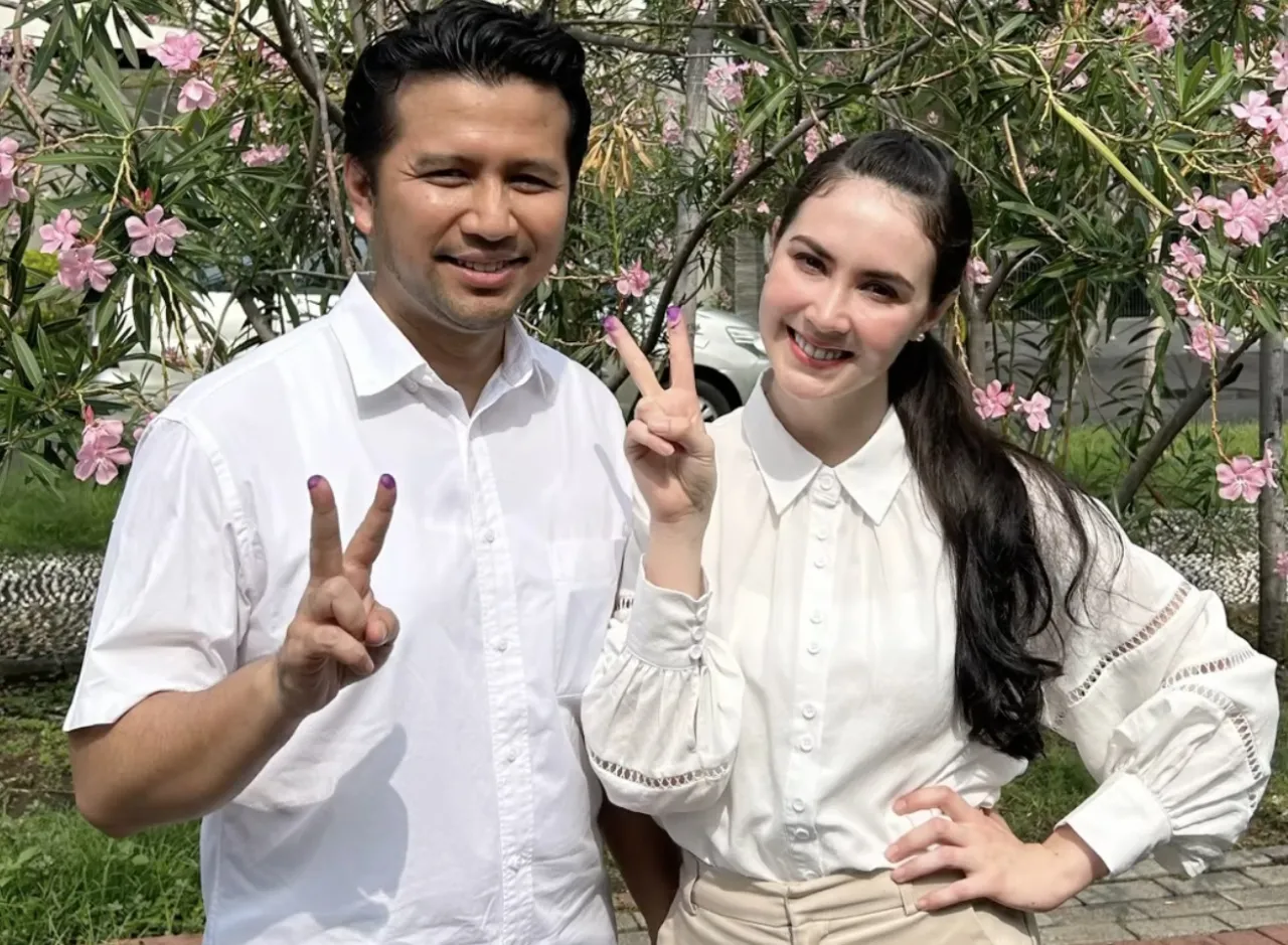 Momen Emil Dardak dan Arumi Bachsin yang terlihat mesra, saat menggunakan hak pilihnya di TPS 15 Kelurahan Margorejo.