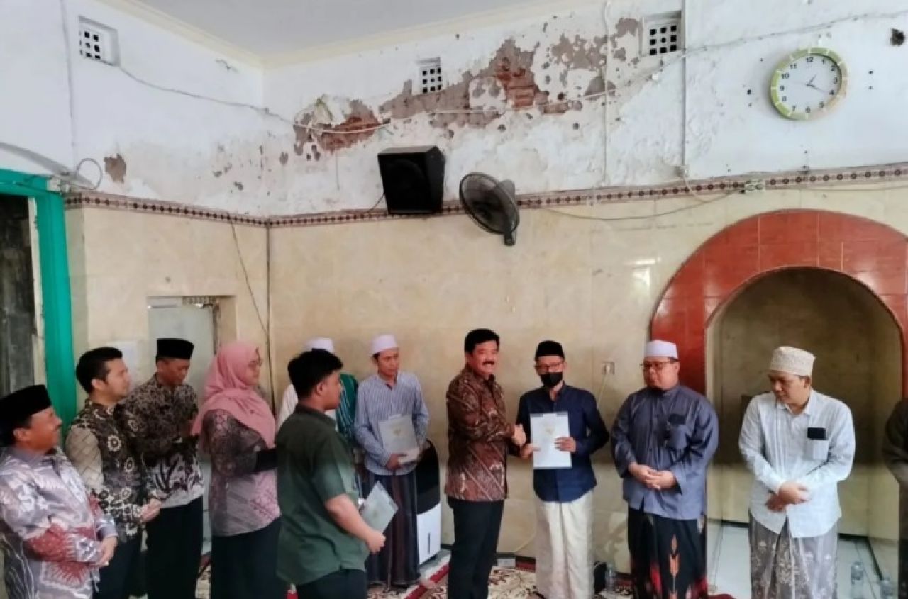 Menteri Agraria dan Tata Ruang/Badan Pertanahan Nasional (ATR/BPN) Marsekal TNI (Purn) Hadi Tjahjanto (batik cokelat) menyerahkan sertifikat tanah wakaf di Surabaya, Rabu (31/1/2024).