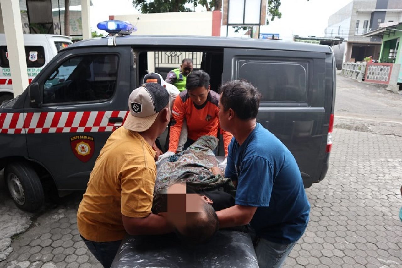 Polisi dan istri korban saat hendak mengevakuasi di salah satu warung tepi jalan ring road Jombang. Selasa (23/1/2024). SP/Sarep