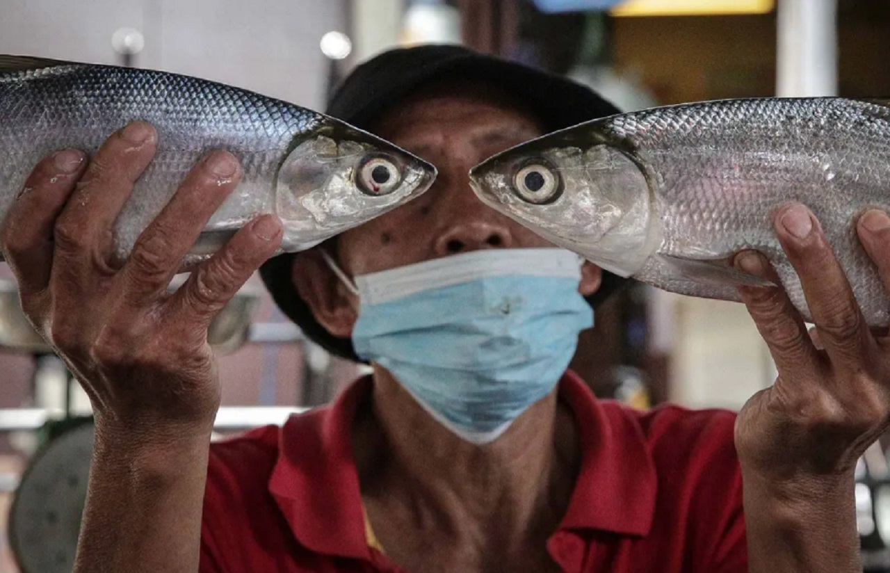 Pedagang menunjukan ikan bandeng di Pasar Petak Sembilan, Glodok, Jakarta. SP/ JKT