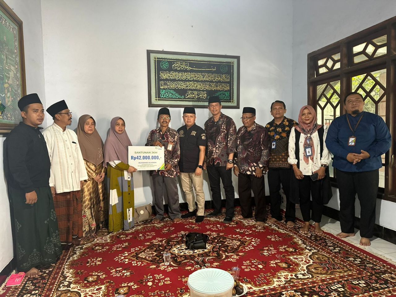 Ketua PCNU Kabupaten Mojokerto saat menyerahkan swcara simbolis santunan kematian kepada ahli waris Almarhum