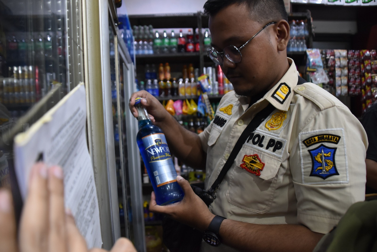 Satpol PP Kota Surabaya merazia toko kelontong yang menjual minuman beralkohol (miho) tanpa izin di Jalan Jarak Surabaya. SP/SURA