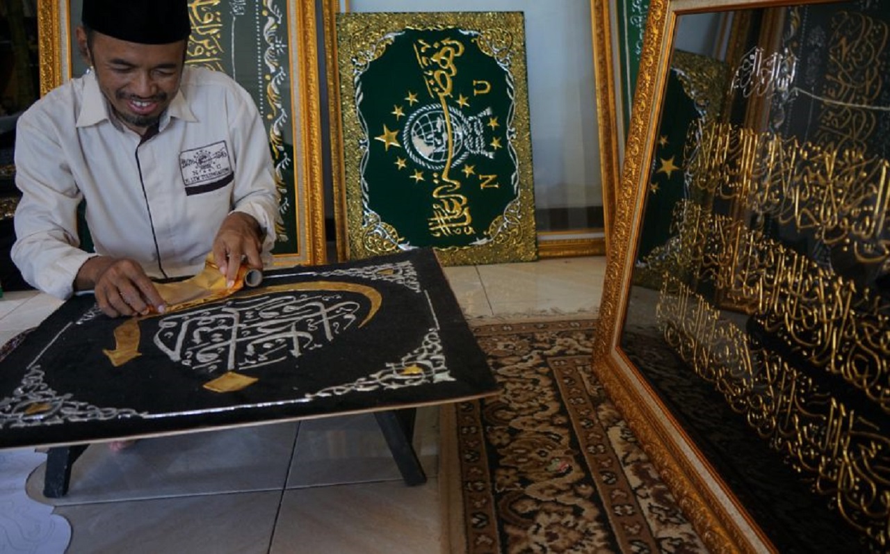 Komarudin saat mengerjakan pesanan kaligrafi. SP/ istimewa