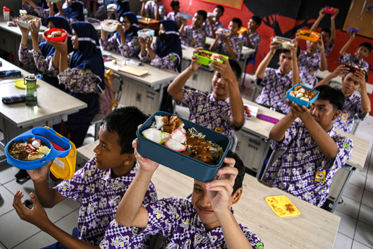 Sejumlah siswa menunjukkan makanan gratis saat simulasi program makan siang gratis di SMP Negeri 2 Curug, Kabupaten Tangerang, Banten. Sulthony Hasanuddin/ Antara