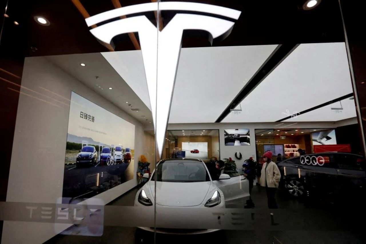 Pengunjung melihat-lihat mobil Tesla Model 3 di samping Model Y yang dipajang di showroom Tesla di Beijing, China (Foto: Reuters-Florence Lo)