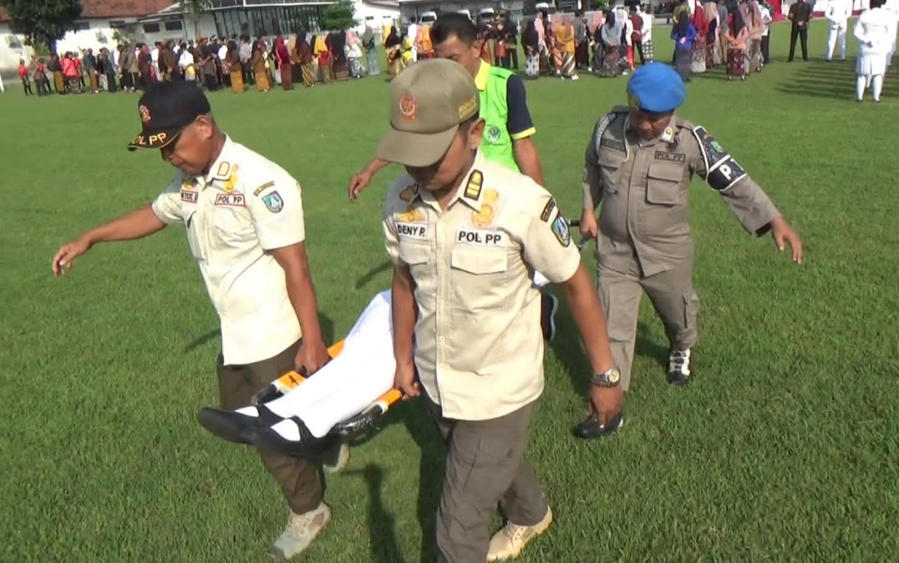 Para peserta upacara Hardiknas di Kabupaten Jombang, yang pingsan langsung ditandu ke tenda medis untuk mendapatkan perawatan. SP/ Rif