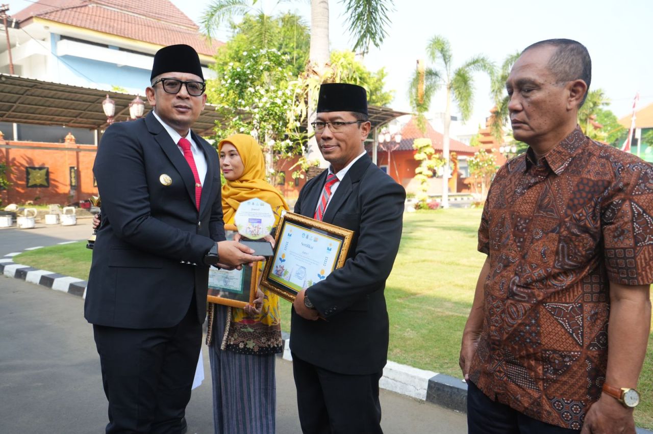 Pj Wali Kota Ali Kuncoro saat menyerahkan penghargaan