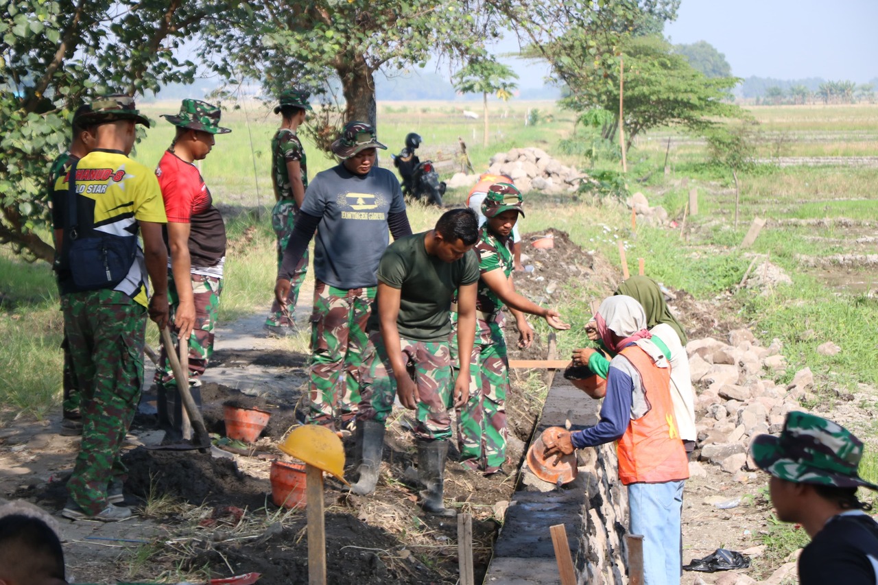 Satgas TMMD ke-120 Kodim 0816/Sidoarjo bersama warga melaksanakan kegiatan pembangunan plengsengan pengairan sawah. SP/ HIKMAH
