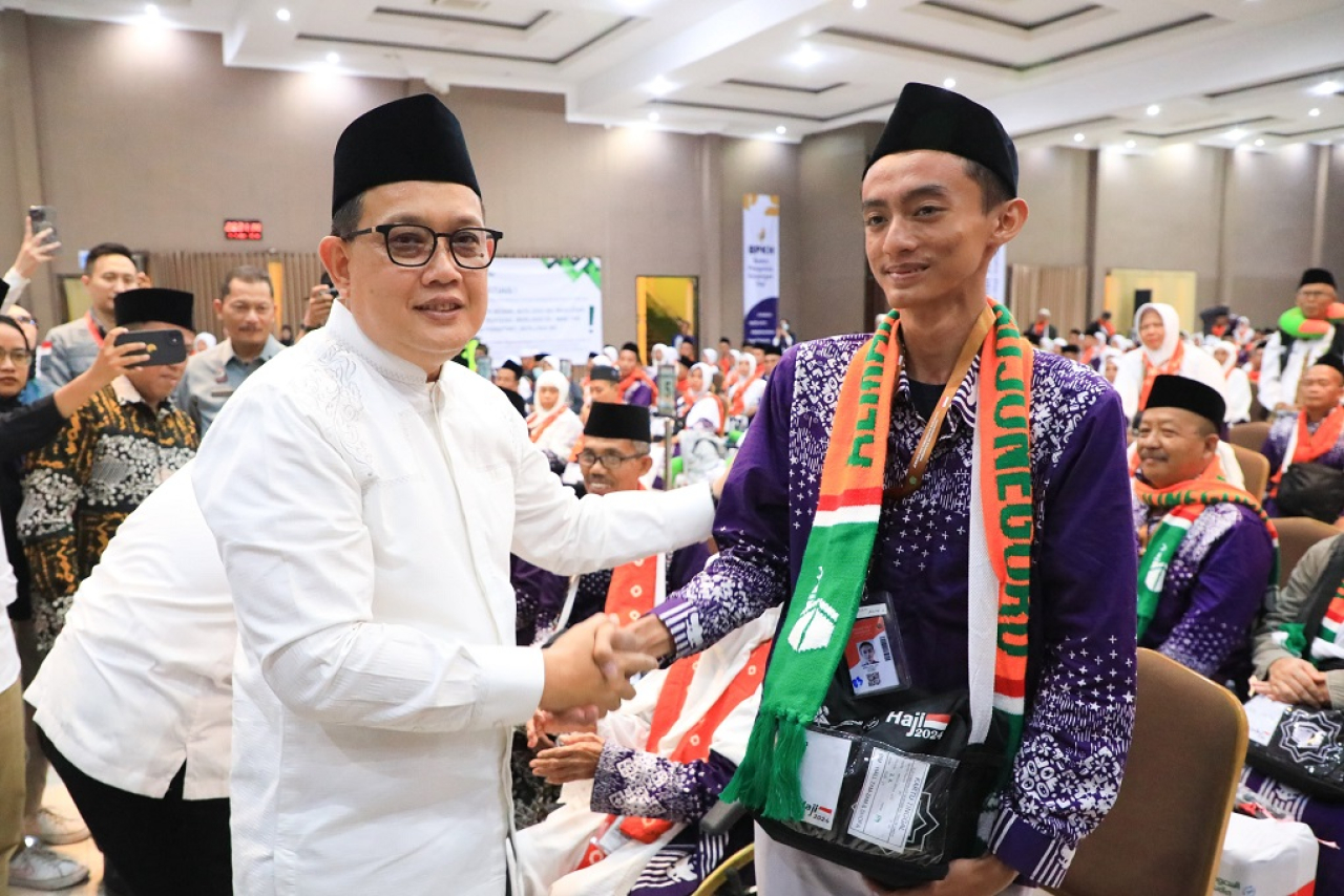 Moch Abdul Aziz, remaja berusia 18 tahun saat diucapkan selamat oleh Pj Gubernur Jatim Adhy Karyono dalam pelepasan kloter pertama CJH Embarkasi Surabaya, Minggu (12/5/2024). SP/Nur Aini