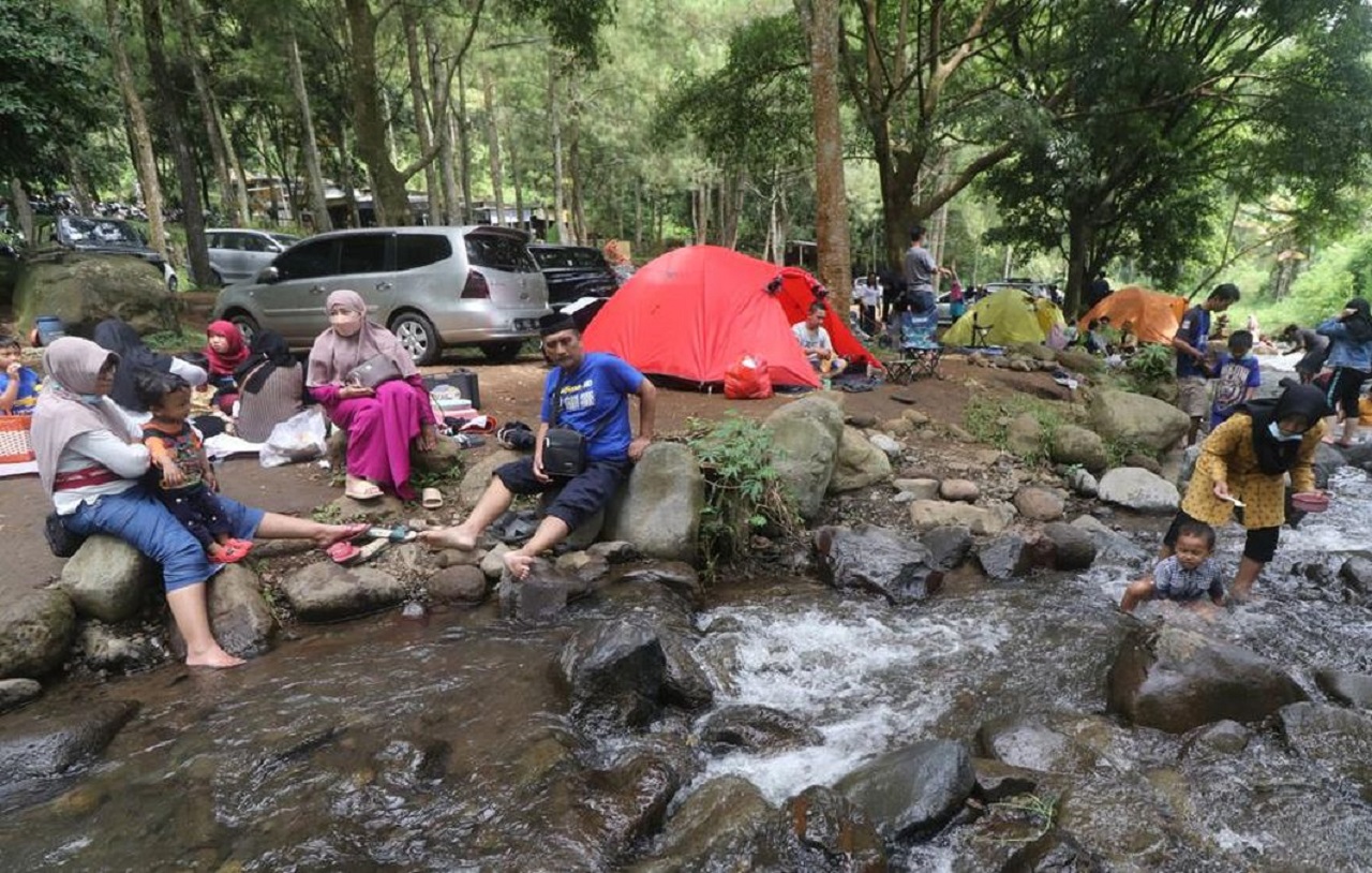 ara wisatawan menikmati suasana di tepi sungai area Bumi Perkemahan Bedengan, Desa Selorejo, Kecamatan Dau, Kabupaten Malang. SP/ MLG