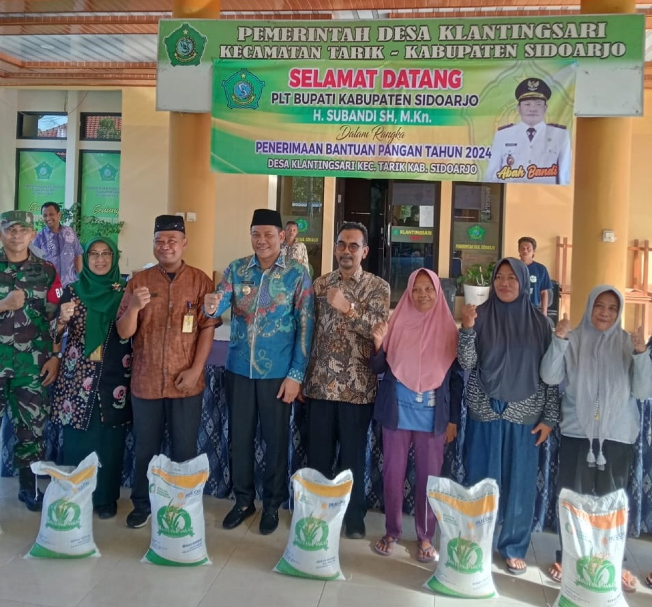 Plt Bupati Sidoarjo, H. Subandi, saat foto bersama pada kegiatan pembagian bansos beras di pendopo kantor desa klantingsari. SP/JUM