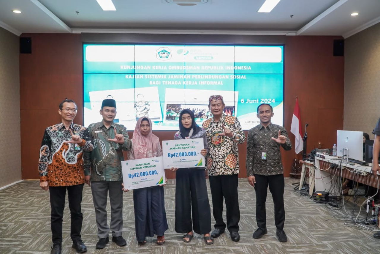 Bupati dan ombudsman berpose bersama dengan penerima wakil atau ahli waris dari perlindungan sosial tenaga kerja informal. SP/MUHAJIRIN