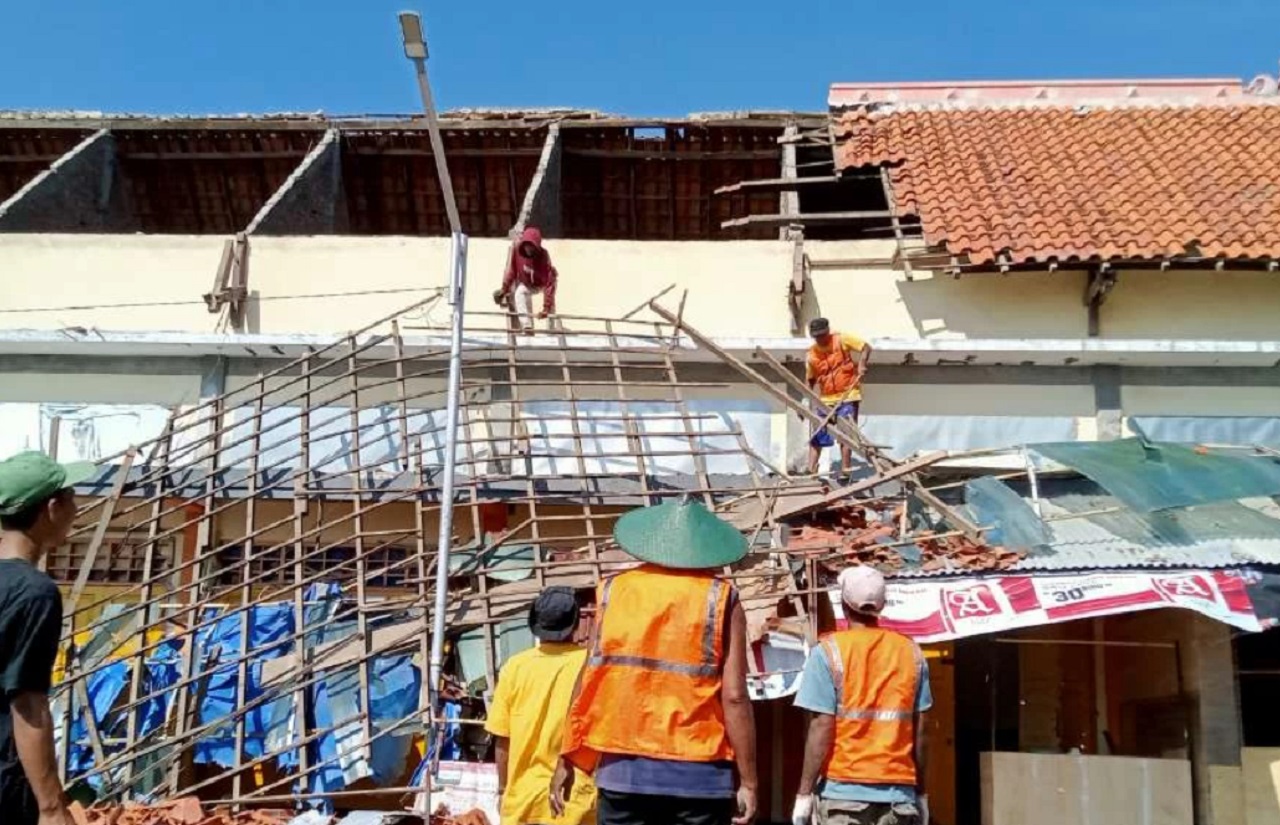 Kondisi salah satu bangunan pasar sore Tuban usai atapnya runtuh. Nampak warga dan abang becak membersihkan puing-puing atap. SP/ TBN