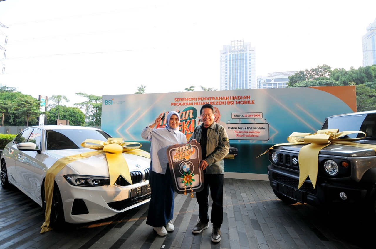 Direktur Utama BSI Hery Gunardi (kanan) menyerahkan hadiah utama  1 (satu) unit mobil BMW 321i kepada nasabah BSI KCP Cianjur Cipanas 2 Siti Rahmawati (kanan) pada acara Seremoni Penyerahan Hadiah Hujan Rezeki BSI Mobile di The Tower Jakarta, Jumat (19/7)