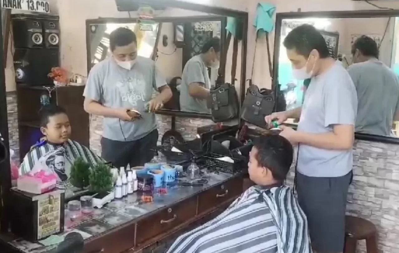Tukang potong rambut di Pasar Kebonagung Kota Pasuruan diserbu siswa jelang masuk sekolah ajaran baru. SP/ PSR