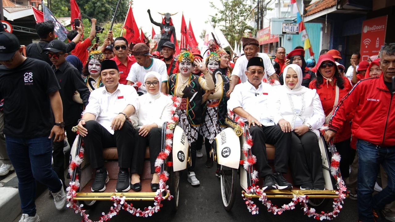 Momen Eri Cahyadi dan Armuji saat melakukan pendaftaran ke KPU Kota Surabaya dengan menumpangi becak dan diarak ribuan pendukung dari 18 parpol yang mengusungnya di Pilkada Surabaya 2024. SP/Alqomar