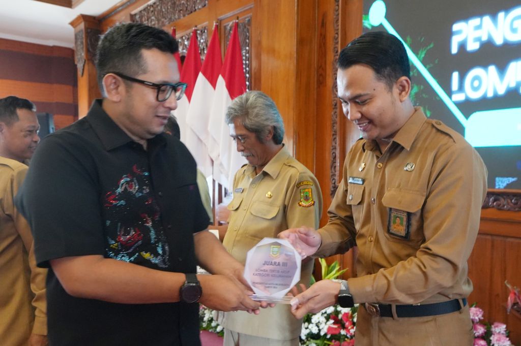 Pj Wali Kota Ali Kuncoro saat menyerahkan hadiah lomba lomba tertib arsip kategori kecamatan, kelurahan dan SMPN tahun 2024 di Sabha Mandala Madya Balai Kota Mojokerto, Selasa (20/8/2024).