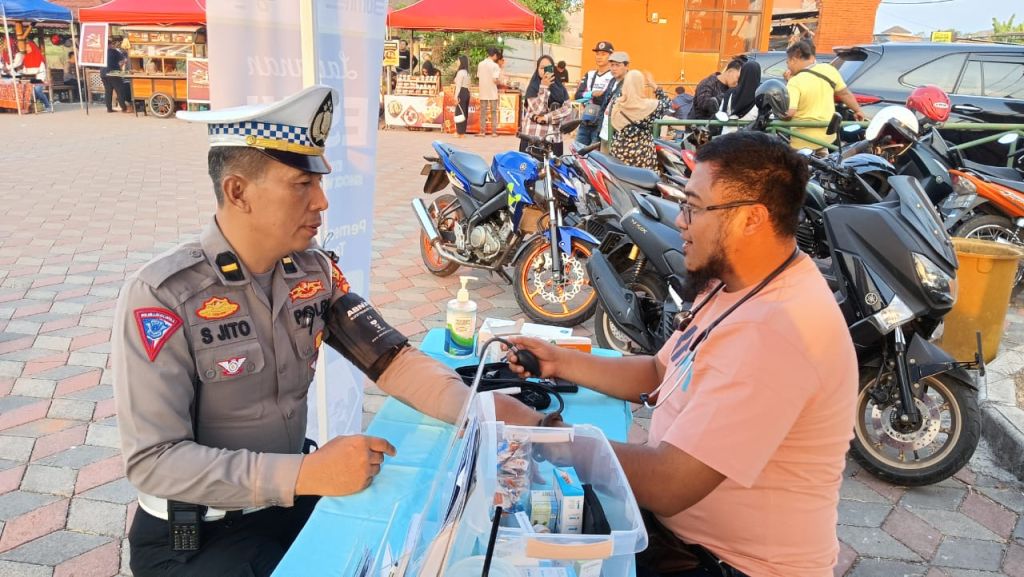 Petugas medis RS Gatoel saat melayani petugas polisi di stand cek up kesehatan gratis