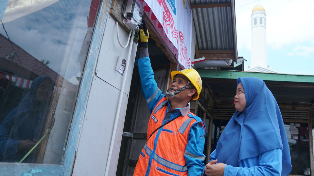 Rona bahagia terpancar dari wajah Jumaidah (kanan) penerima manfaat program Light Up The Dream di Kecamatan Gandus, Palembang oleh petugas PLN. Foto/Humas PLN