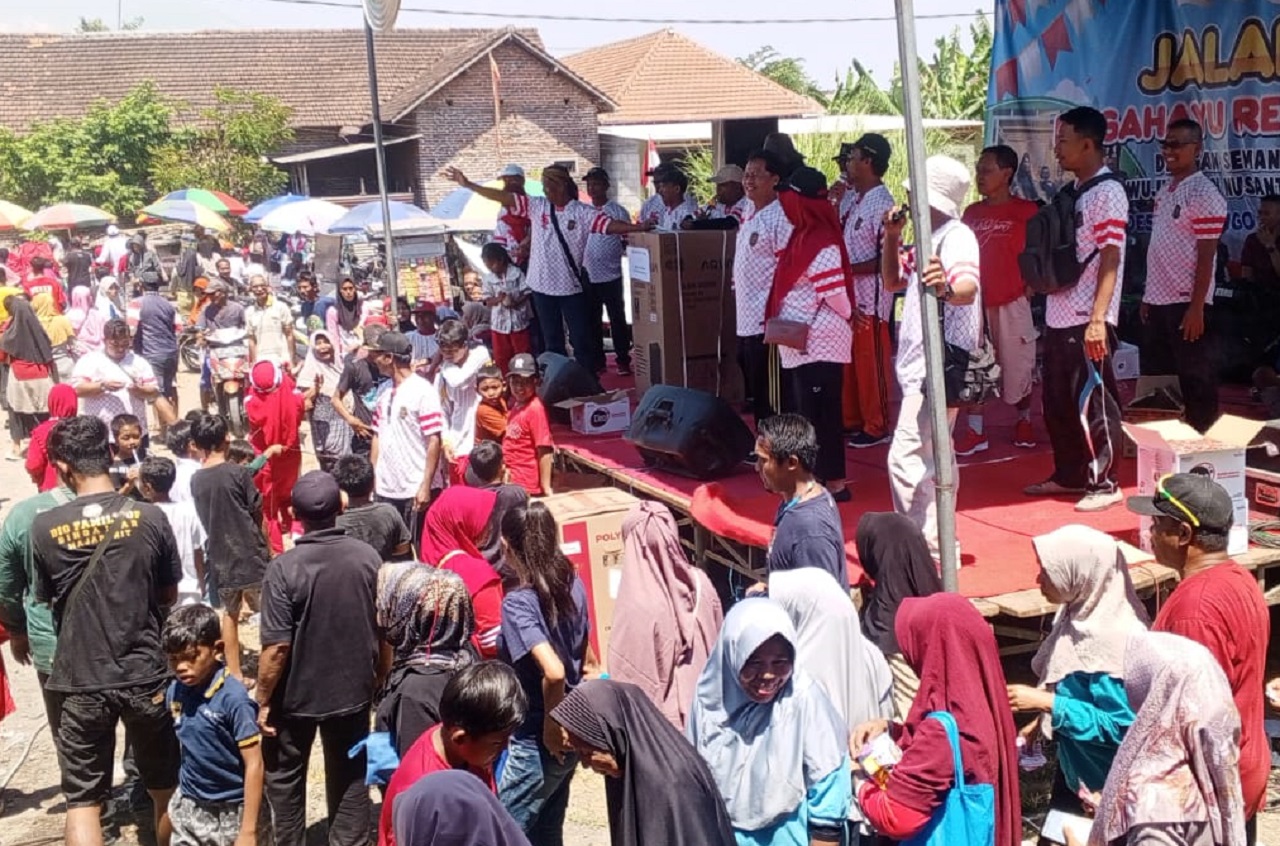 M. Husin Kepala Desa Kenongo menyerahkan hadiah utama jalan sehat. SP/ HIKMAH