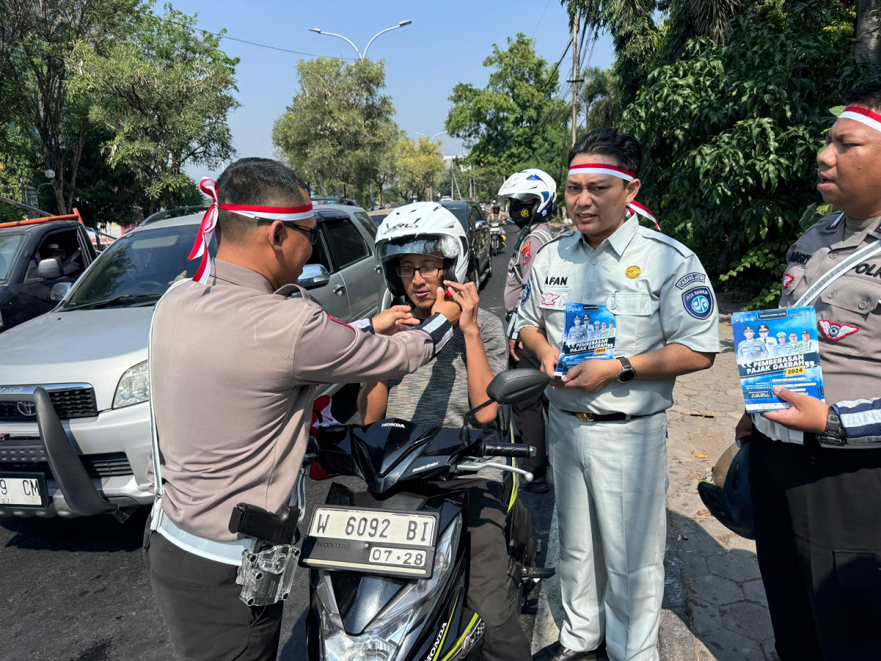 Petugas saat membagikan helm gratis kepada pengemudi yang melintas. SP/M Aidid