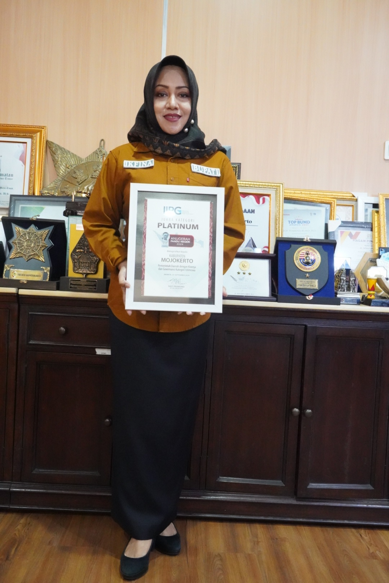 Bupati Mojokerto Ikfina Fahmawati saat memamerkan piagam penghargaan Anugerah Pandu Negeri 2024 dari IIPG.