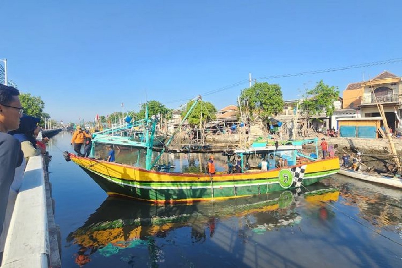 Para nelayan yang dibantu BPBD Kota Pasuruan sedang menarik kapal yang tenggelam setelah bagian lambung kapal pecah akibat bebatuan di dasar sungai. SP/ PSR