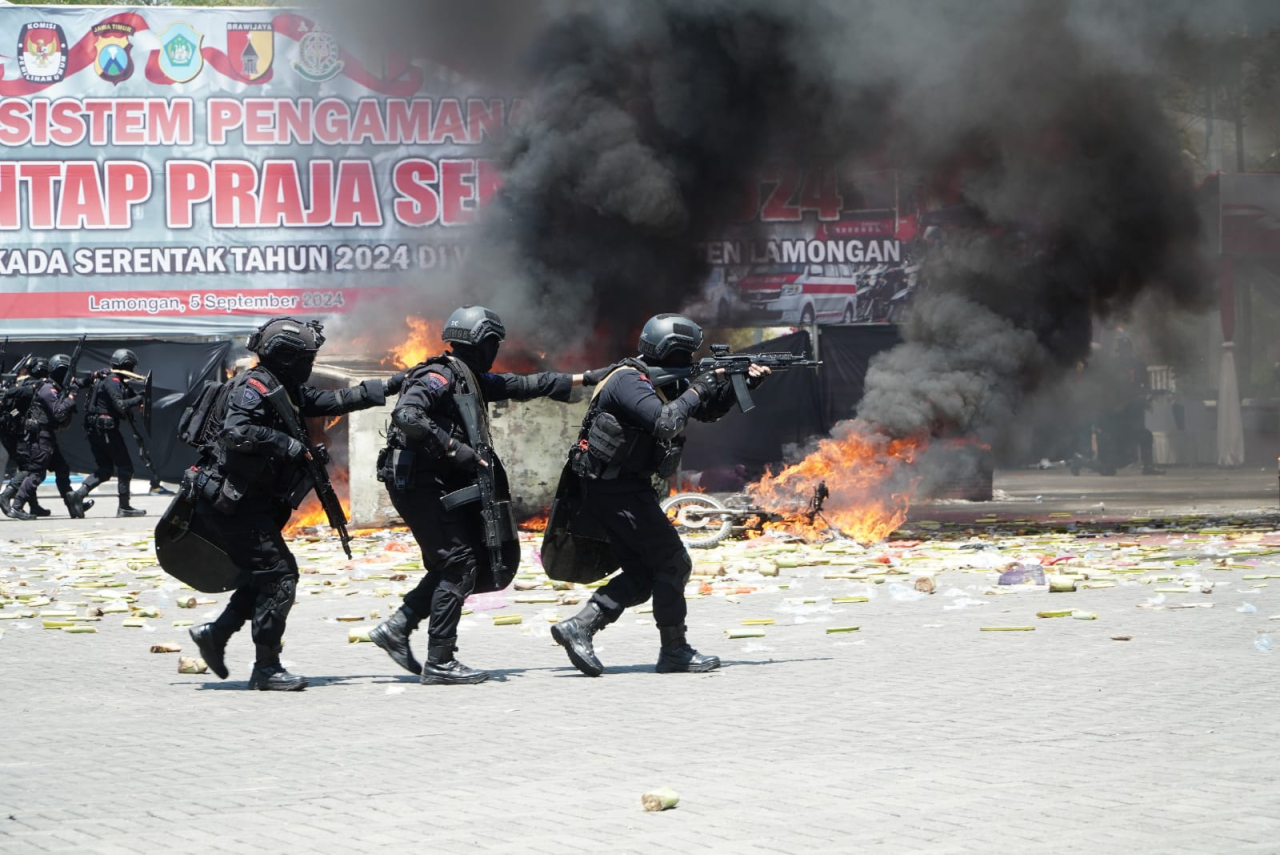 Simulasi peragaan menghalau demo oleh petugas yang berujung kerusuhan dalam proses pengamanan hasil pemilu di Alun-alun Lamongan. SP/MUHAJIRIN 