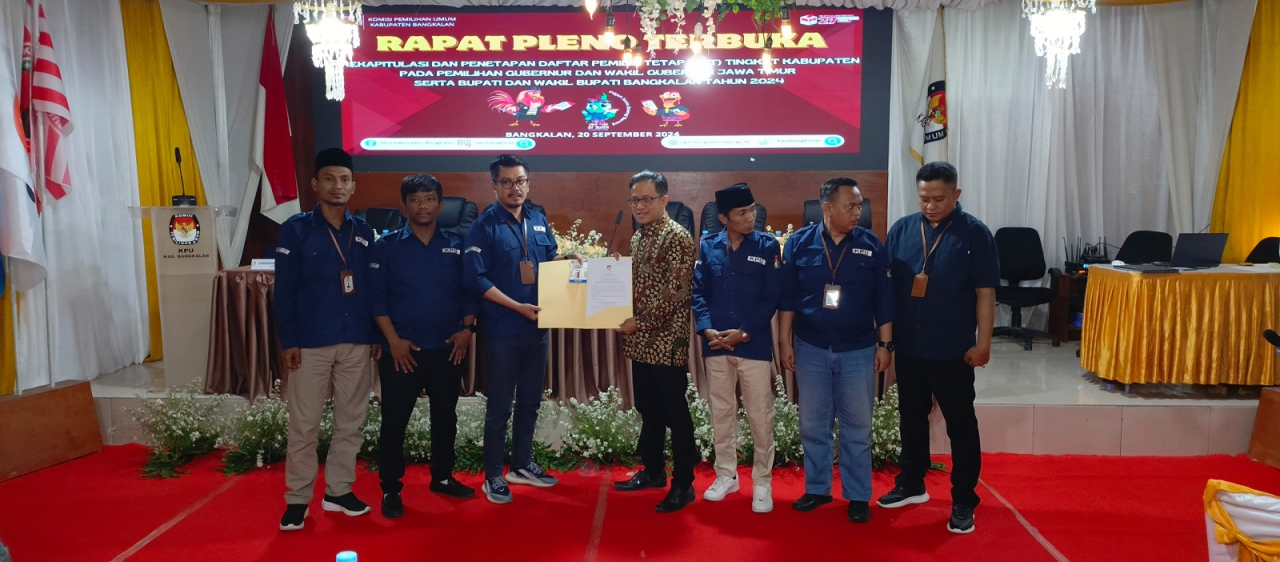 Ketua KPU Bangkalan Elmi Abbas (kanan) menyerah Berkas DPT kepada komisioner Bawaslu Malikul Amin (pakai Batik)